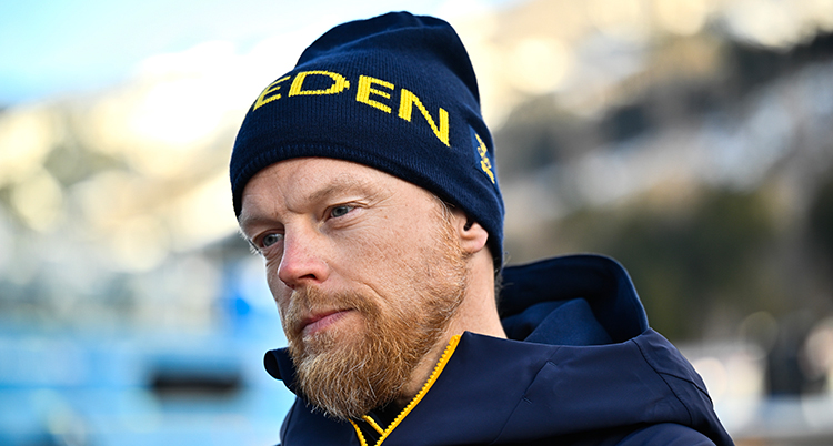 Ett porträtt. Han har skägg och mössa.