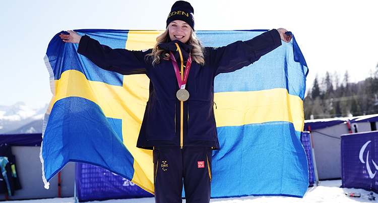 Ebba håller en stor svensk flagga bakom sig.