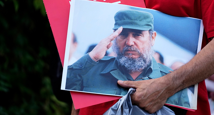 En hand håller en bild på Fidel Castro.