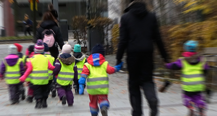 Barn i västar går på rad.