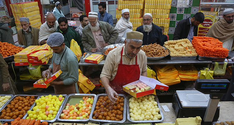 Män ordnar med sötsaker på marknaden.