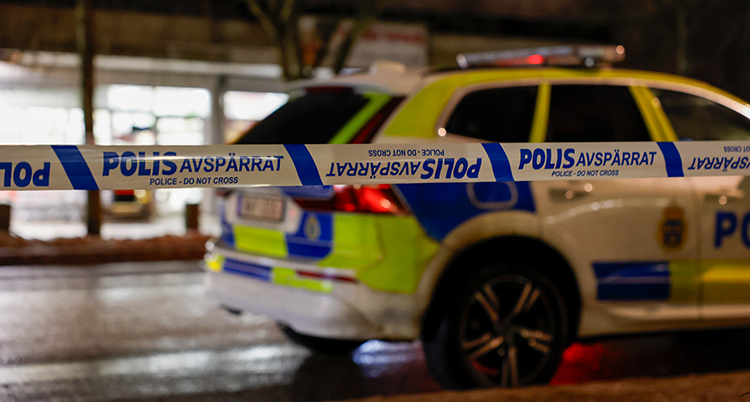Poliserna har spärrat av ett område. En polisbil har parkerat vid gatan.