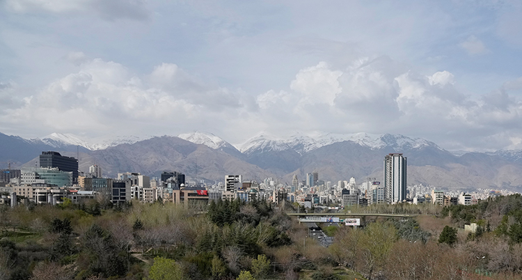 En vy som visar staden Teheran. I bakgrunden syns berg med snö.