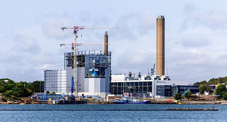 Kraftverket ser ut som en stor fabrik. Det ligger vid havet.
