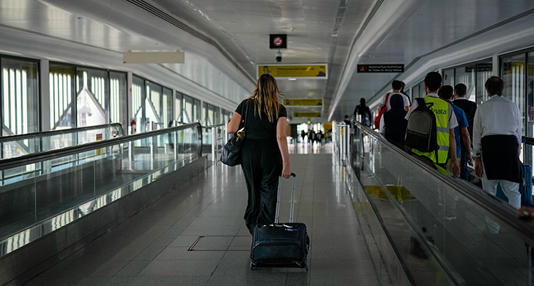 Hon går med sin resväska.