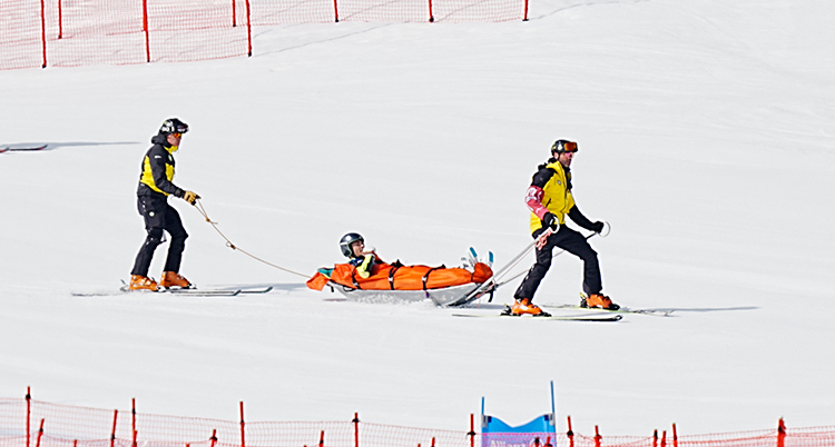 Två personer kör Aaron Lindström i en pulka.