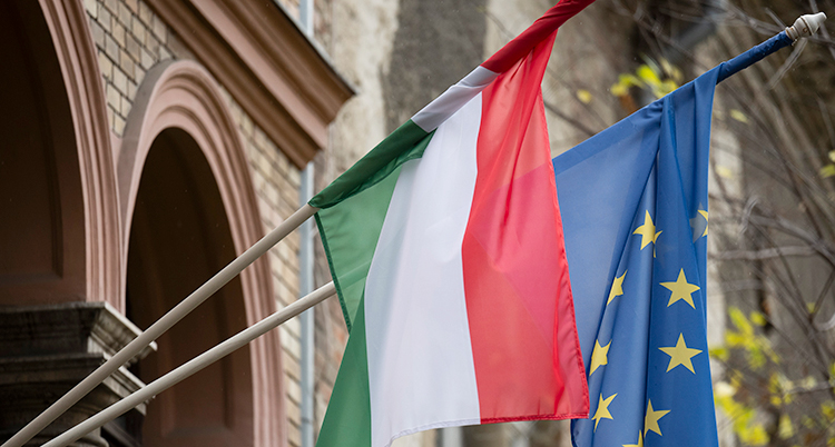 Två flaggor hänger på ett hus.