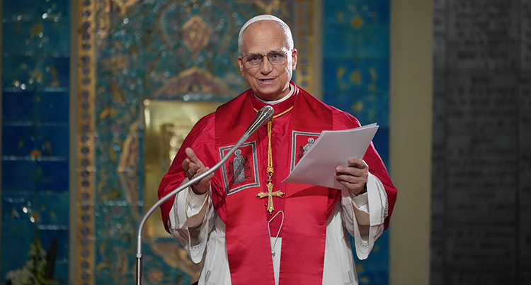 Påven står i en kyrka och pratar i en mikrofon.