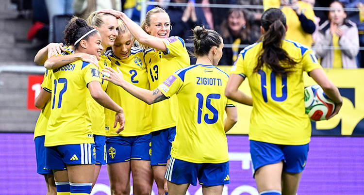 Från en match i fotboll. Svenska spelare kramar varandra efter ett mål.