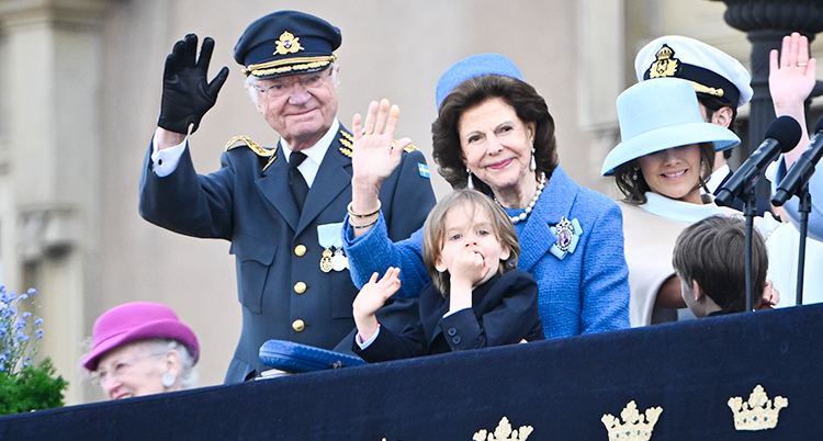 De står tillsammans och vinkar vid slottet i Stockholm.