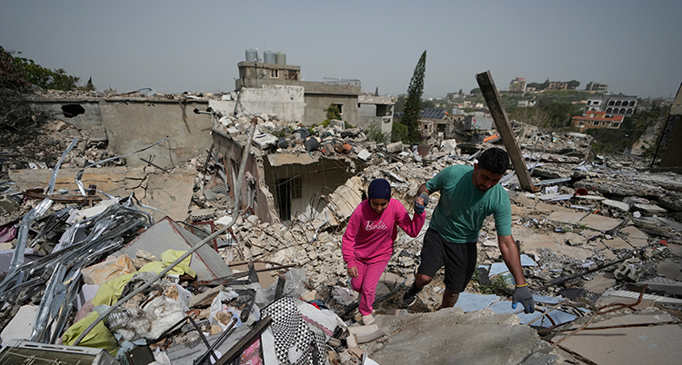 Hus har rasat ihop. De går över dem.