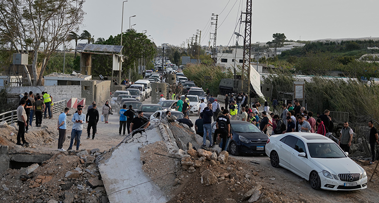 Bilar och människor trängs på en gata.