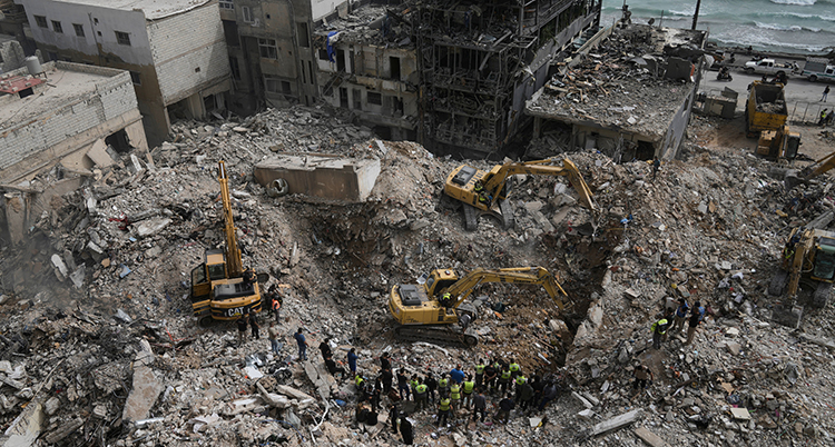 Flera grävmaskiner gräver i ras efter hus.