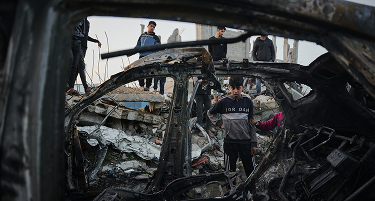 Fyra personer tittar på en trasig bil.