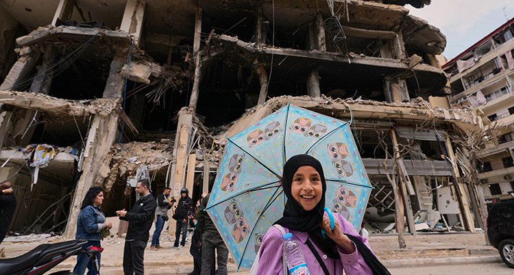 Hon är glad och håller i ett paraply i turkos färg.