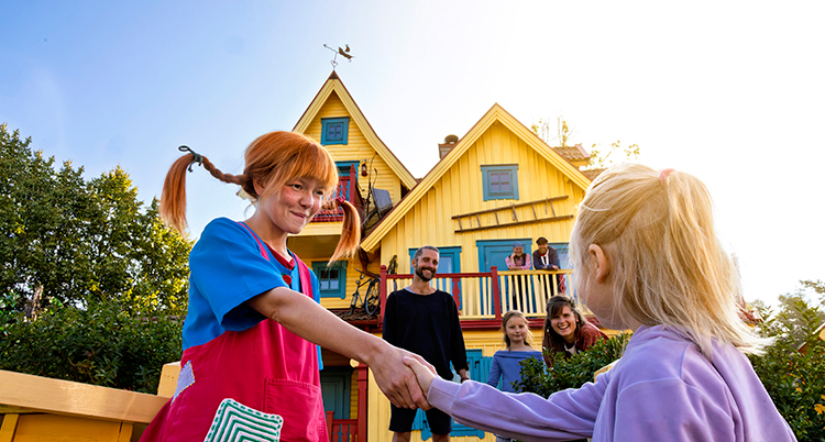 Pippi Långstrump skakar hand med ett barn.