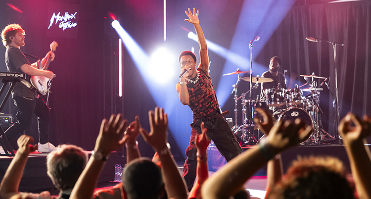 Han viftar med handen till publiken.