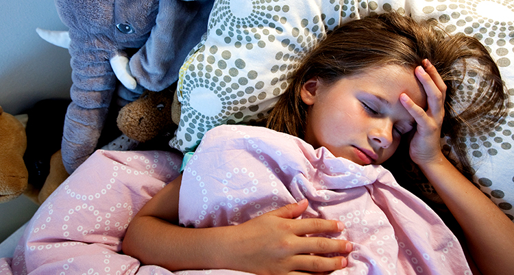 En flicka ligger på en kudde och sover.