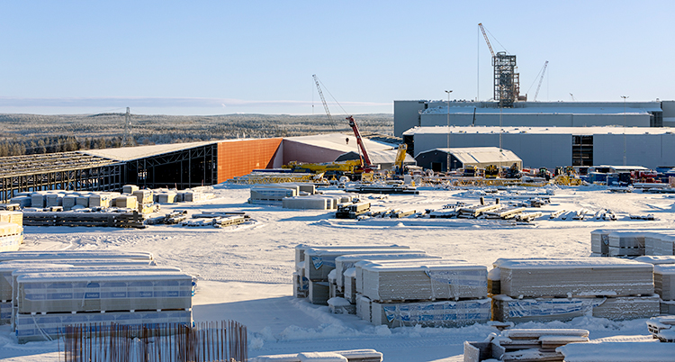 Det är vinter på bilden och snö. Ett stort bygge av en fabrik.