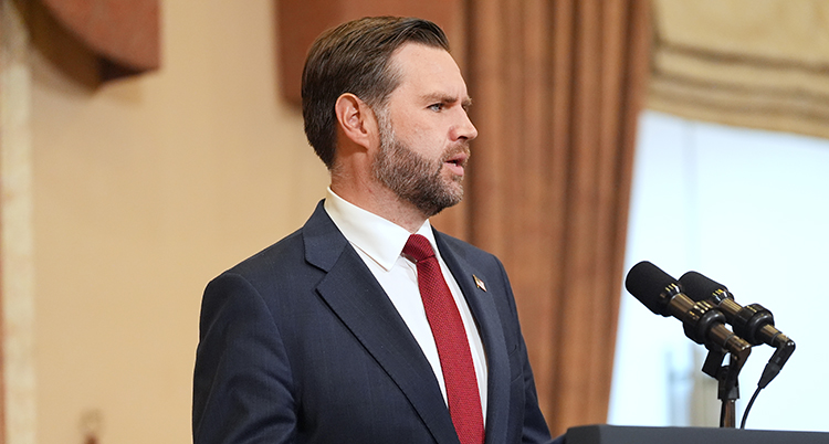 Han står vid en mikrofon.