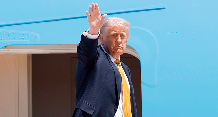 Donald Trump vinkar vid ingången till ett flygplan.