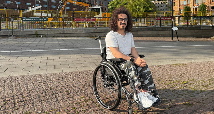 En man i en rullstol på en trottoar.