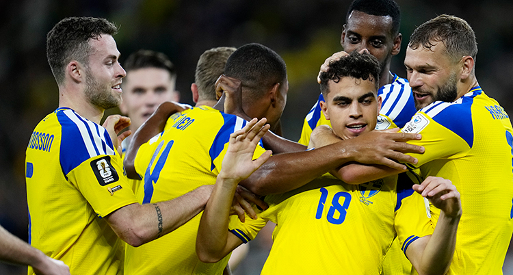 Han kramas om av en grupp glada spelare.