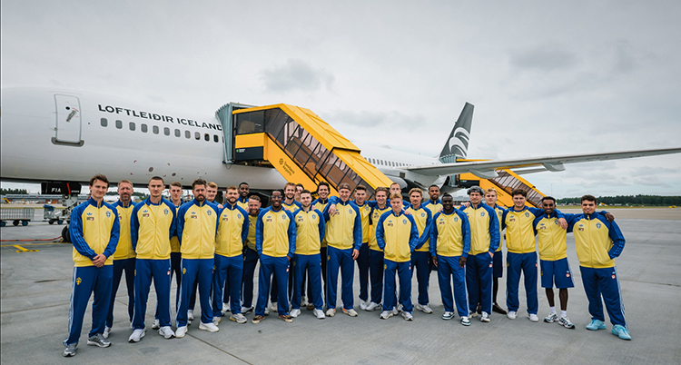 De står framför ett flygplan.