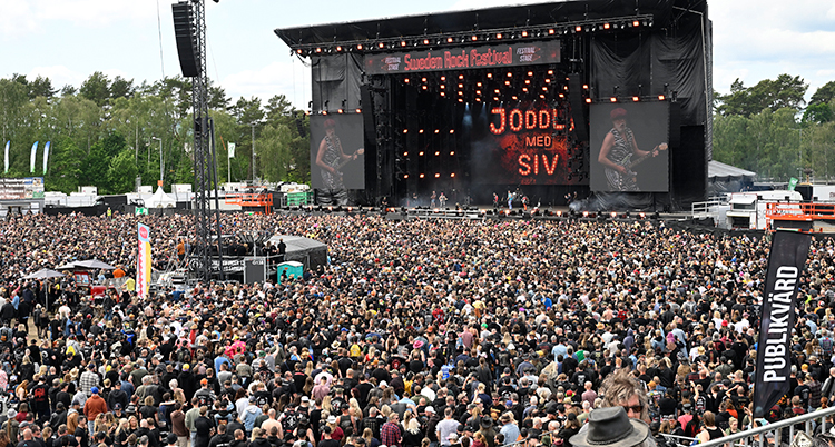 Fullt med människor framför en stor scen.