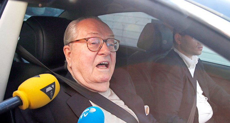 Han sitter i en bil och blir intervjuad av journalister.