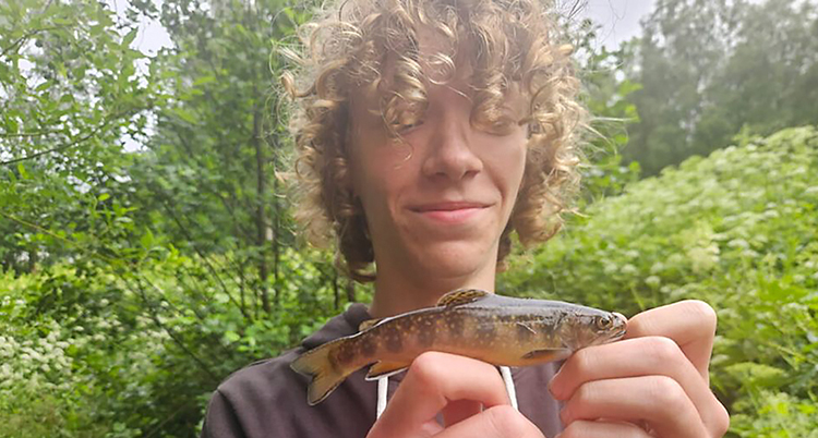 Han håller fisk med båda händerna.
