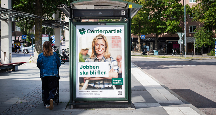 En busskur med en affisch i. Jobben ska bli fler står det.