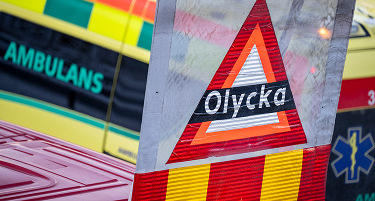 En ambulans och en skylt som det står olycka på syns.