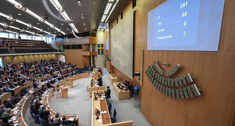 Salen i riksdagen. Politikerna sitter ner och trycker på knappar när de röstar.