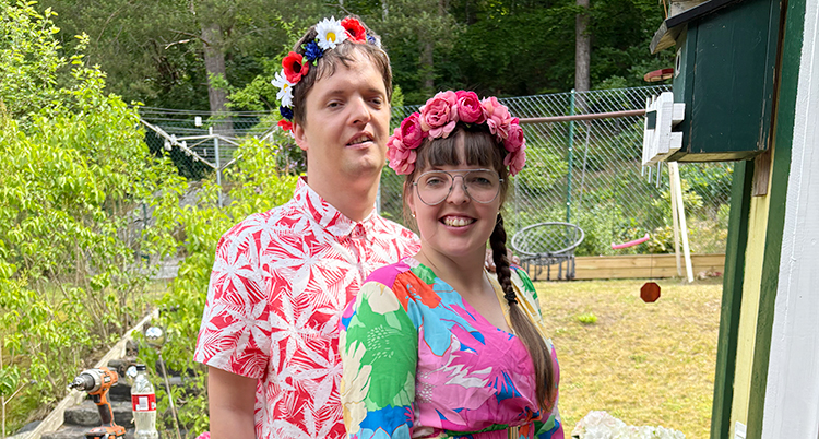 De står bredvid varandra. De har kransar med blommor i håret.