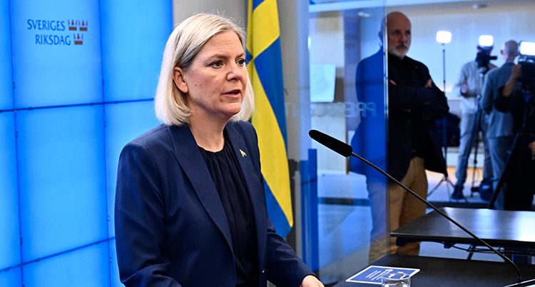 Hon talar framför en mikrofon.