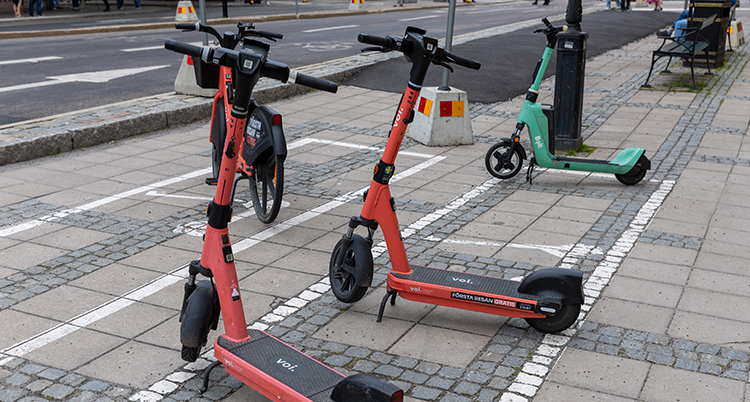 Elsparkcyklar på en trottoar.