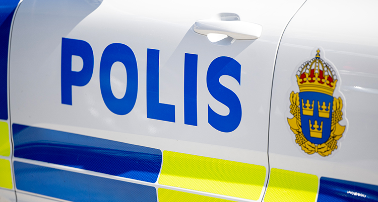 En del av en polisbil. Det står polis på dörren till bilen.