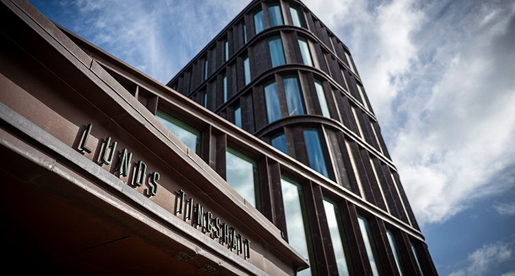 En flera våningar hög byggnad med rundade hörn fotad underifrån.