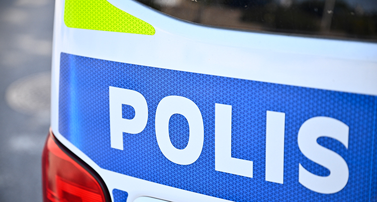 En skylt på en polisbil. Polis står det på skylten.
