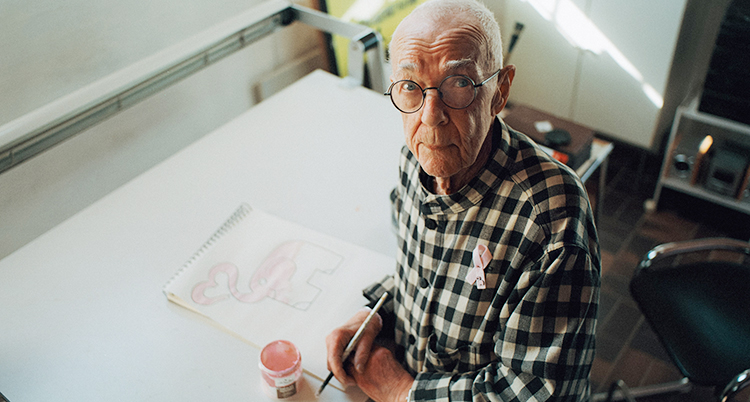 Han sitter och tittar upp mot kameran. Han är 86 år.