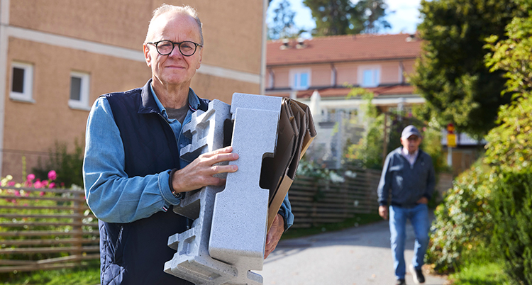 Han håller i kartonger som ska slängas.