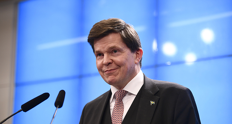 Han ler och står framför en mikrofon.