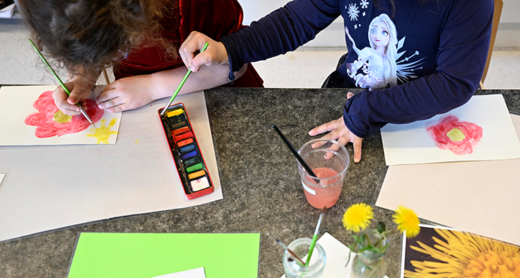 Barn målar blommor på en förskola.