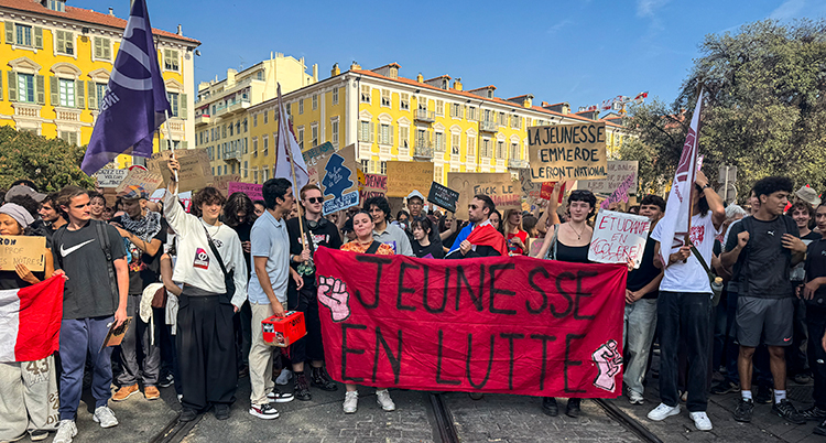Flera ungdomar håller i en stor skylt.